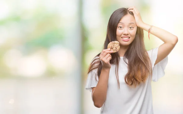 Mujer Asiática Joven Comiendo Galletas Chocolate Sobre Fondo Aislado Estresado — Foto de Stock