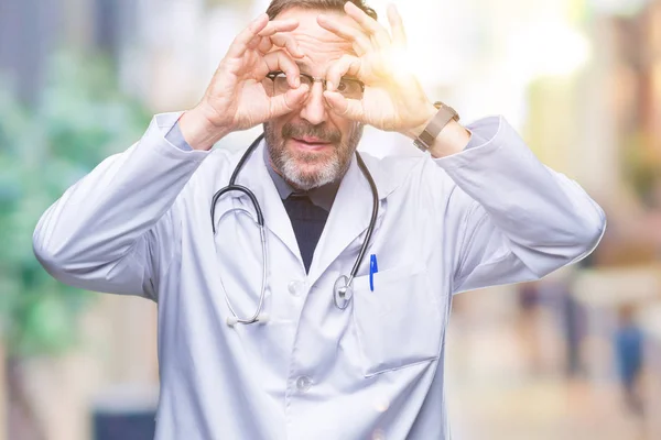 中年先輩の白髪医師男着て医療制服は 舌を出して指を通して見る目をこだわりの双眼鏡のような ジェスチャーを行う背景を分離しました クレイジー式 — ストック写真