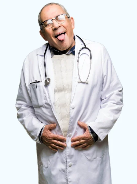 英俊的资深医生穿着医用外套伸出舌头高兴与搞笑的表情 情感概念 — 图库照片