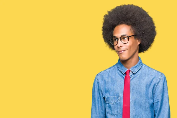 アフロ髪眼鏡と赤いネクタイが自然な表現の顔に笑みを浮かべて側に離れて見て若いアフリカ系アメリカ人ビジネスマン自信を持って笑ってください — ストック写真
