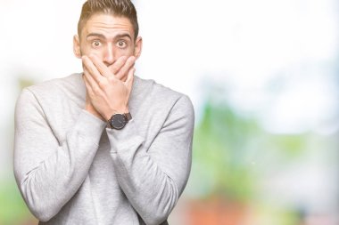 Üzerine tişört giyen genç yakışıklı adam arka plan ağız hata için elleriyle kapsayan şok izole. Gizli kavramı.