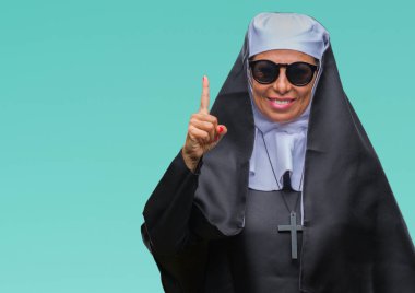 Orta yaş üst düzey Katolik Rahibe kadın başarılı fikirle izole arka plan işaret parmağı üzerinde güneş gözlüğü takıyor. Çıktıktan ve mutlu. Bir numara.