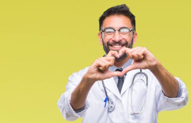 Yetişkin İspanyol doktor adam aşık kalp simgesi ve elleriyle şekil gösteren gülümseyen izole arka plan üzerinde. Romantik kavramı.