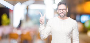 Mutlu yüz zafer işareti yaparken kameraya göz kırpıyor ile gülümseyen izole arka plan üzerinde gözlük takan yakışıklı delikanlı. İki numaralı.