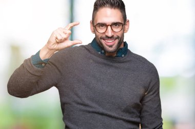 İzole arka plan gülümseyen ve süre seyir ve kamera boyutu işaret parmaklarıyla yapıyor el ile kendinden emin eller üzerinde gözlük takan yakışıklı delikanlı. Ölçü kavramı.