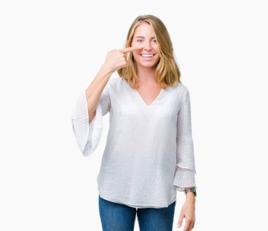 Güzel genç zarif kadın yüzünden izole arka plan işaretçi el parmak yüz ve burun, neşeli gülümseyen