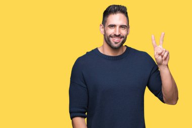 Gösterilen arka plan üzerinde kazak giyen genç yakışıklı adam izole ve parmakları ile işaret kendinden emin ve mutlu gülümseyerek ise ikinci.