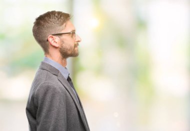 Genç yakışıklı iş adamı izole arka tarafına, seyir üzerinde dinlenmek doğal yüz emin gülümseme ile pozuyla profili.