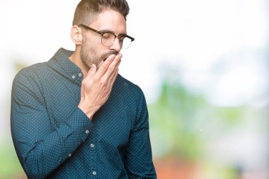 Genç yakışıklı iş adamı izole arka plan üzerinde gözlük el ağzıyla kapsayan yorgun esneme sıkılmış. Restless ve uyku hali.