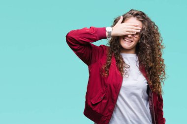 Güzel esmer kıvırcık saçlı Genç kız gülümsüyor ve gözleri için sürpriz kapsayan yüz el ile gülüyor izole arka plan üzerinde ceket ve gözlük takıyor. Kör kavramı.