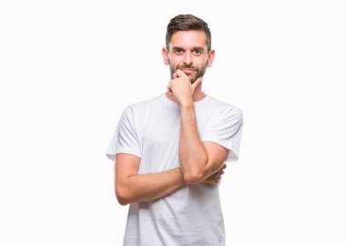 Yakışıklı delikanlı emin çapraz kollar ve çeneme kaldırdı el ile gülümseme ile kameraya bakarak izole arka plan üzerinde. Pozitif düşünce.