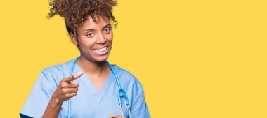 Genç Afro-Amerikan doktor kadın kamera ile mutlu ve komik yüz için parmakları işaret izole arka plan yüzünden. İyi enerji ve vibes.