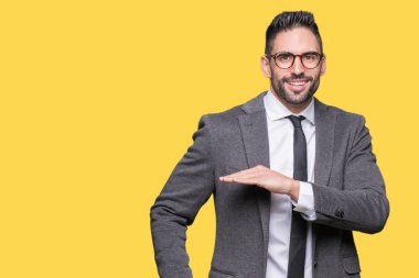 Genç yakışıklı iş adamı izole arka plan eller eller büyük gösterilen ve büyük boy işareti, ölçü birimi sembolü ile üzerinden. Kameraya bakarak gülümsüyordu. Ölçüm kavramı.