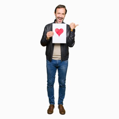 İşaret ve başparmak kadar mutlu yüz gülümseyen tarafı ile gösterilen Kırmızı kalp ile kağıt tutan yakışıklı orta yaş erkek