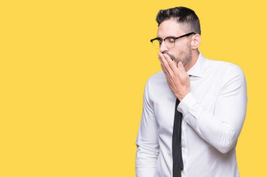 Genç yakışıklı iş adamı izole arka plan üzerinde gözlük el ağzıyla kapsayan yorgun esneme sıkılmış. Restless ve uyku hali.