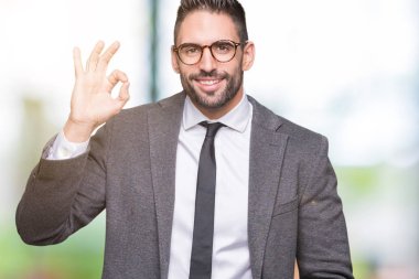 Genç yakışıklı iş adamı izole arka plan el ve parmaklar ok işaretiyle yapıyor olumlu gülümseyen üzerinde. Başarılı ifade.