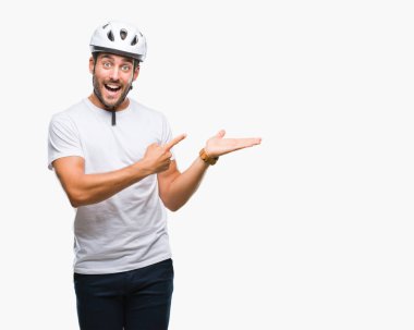 Yakışıklı delikanlı üzerinden hayran ve el ile sunulması ve parmak ile işaret ederken kameraya gülümseyen izole arka plan bisikletçi Güvenlik kask giyiyor.