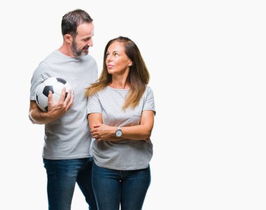 Orta yaş İspanyol çift acımak yüz ciddi düşünüyorum üstünde kendine güvenen bir ifade ile izole arka plan üzerinde futbol futbol topu tutan