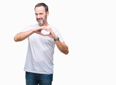 Kalp simgesi ve elleriyle şekil gösterilen aşık gülümseyen izole arka plan üzerinde beyaz t-shirt giyen orta yaş ağarmış komuta sizde. Romantik kavramı.