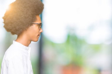 Tarafına, seyir güneş gözlüğü takıyor afro saçlı genç Afro-Amerikan adam sakin ol kendine güvenen gülümseme ile doğal yüz pozuyla profili.