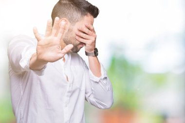 Genç iş adam elleriyle gözlerini kapsayan izole arka plan üzerinde ve stop jest ile acı ve korku ifadesi. Utandım ve negatif kavramı.