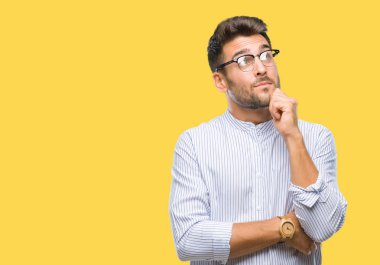 Yakışıklı delikanlı çene düşünme hakkında soru, dalgın ifade üzerine el ile izole arka plan üzerinde. Düşünceli yüzüyle gülümsüyor. Şüphe kavramı.