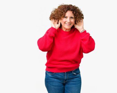 Güzel orta ager üst düzey kadın kırmızı kış kazak her ikisi de dinliyoruz izole arka plan üzerinde kulak jest, dedikodu için meraklı eller. İşitme sorunu, sağır