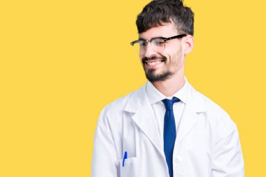 Üzerinde beyaz önlük giyen genç profesyonel bilim adam arka plan uzak tarafına gülümseme ile yüzünde, doğal ifade arıyorum izole. Kendine güvenen gülüyor.