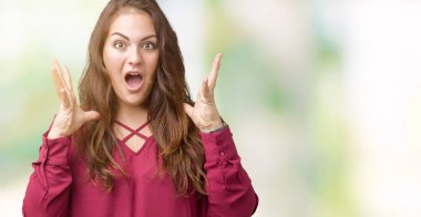 Artı boyutu genç kadın çılgın ve silah ile başarı için hayran izole arka plan kutlama üzerinde güzel çığlık kaldırdı ve açık gözleri heyecanlı. Kazanan kavramı