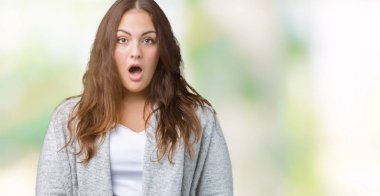 Artı boyutu genç kadın güzel giyen kış ceket korkuyor ve şok sürpriz ifade ile izole arka plan üzerinde korku ve yüz heyecanlı.