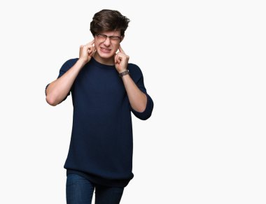 Yüksek sesle müzik gürültü rahatsız ifade parmaklarıyla kulaklarıyla kapsayan izole arka plan üzerinde gözlük takan yakışıklı delikanlı. Sağır kavramı.