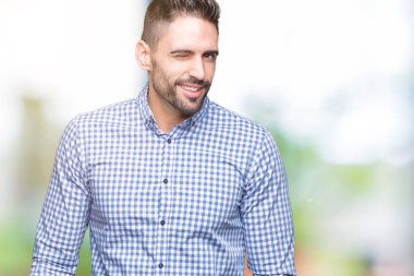 Genç yakışıklı adam seksi bir ifadeyle, neşeli ve mutlu yüzünü kameraya bakarak göz kırpıyor izole arka plan üzerinde.