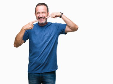 Orta yaş emin gösterilen ve işaret parmakları diş ve ağız ile gülümseyen izole arka plan üzerinde ağarmış komuta sizde. Sağlık kavramı.