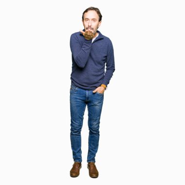 Orta yaş yakışıklı adam öpücük el ile güzel ve seksi olmak yayına üfleme kamera bakarak bir kazak giyiyor. Aşk ifade.