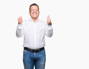 Orta yaş Arap zarif adam izole arka kolları olan başarı için heyecan üzerinde zafer kutluyor gülümseyen kaldırdı. Kazanan kavramı.