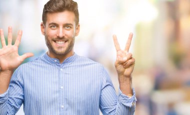 Yakışıklı delikanlı gösterilen ve parmakları ile işaret izole arka plan üzerinde kendinden emin ve mutlu gülümseyerek süre yedi numara.