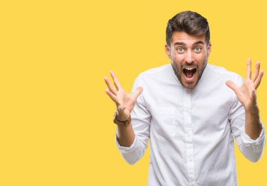 Yakışıklı delikanlı deli kutluyor ve silah ile başarı için heyecanlı çığlık kaldırdı ve açık gözleri hayret izole arka plan üzerinde. Kazanan kavramı