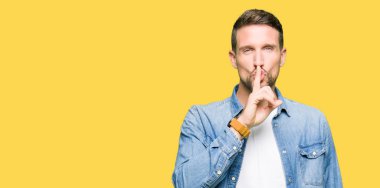 Dudaklarında parmak ile sessiz olmanı denim ceket giyen sakal ve mavi gözlü yakışıklı adam. Sessizlik ve gizli kavramı.