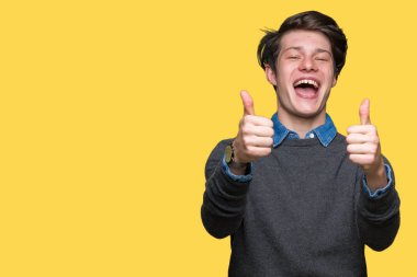 Genç yakışıklı zarif adam el ile pozitif jest yapıyor onaylama izole arka plan üzerinde başparmak gülümseyen ve başarı için mutlu. Kamera, kazanan jest arıyorsunuz.