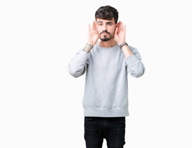 Her ikisi de dinliyoruz izole arka plan üzerinde sweatshirt giyen genç yakışıklı adam kulak jest, dedikodu için meraklı eller. İşitme sorunu, sağır