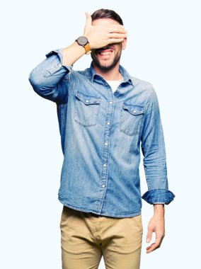 Yakışıklı adam gülümsüyor ve gözleri için sürpriz kapsayan yüz el ile gülüyor gözlük takıyorum. Kör kavramı.