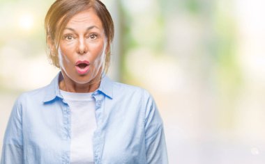 Orta yaş üst düzey İspanyol kadın izole arka plan korkuyor ve sürpriz ifade ile şok yüzünden korku ve yüz heyecanlı.