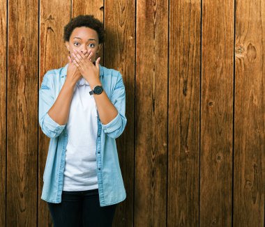 Üzerinde kulaklık giyen genç Afro-Amerikan kadın arka plan ağız hata için elleriyle kapsayan şok izole. Gizli kavramı.