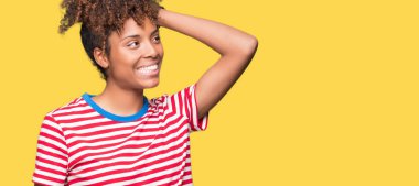 Güzel genç Afro-Amerikan kadın hareketi el ile kendine güvenen dokunaklı saç gülümseyerek, çekici poz izole arka plan üzerinde