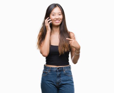 Sürpriz yüz işaret parmağı izole arka plan üzerinde kendi kendine konuşan Genç Asyalı kadın