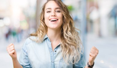 İzole arka plan kutlama üzerinde güzel sarışın genç kadın şaşırttı ve başarı için kaldırdı kollarını açarak hayret ve gözleri açık. Kazanan kavramı.