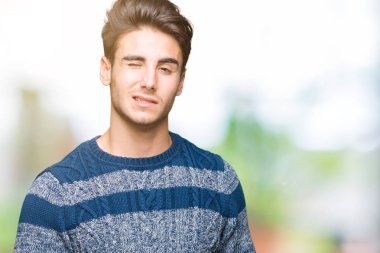 Genç yakışıklı adam seksi bir ifadeyle, neşeli ve mutlu yüzünü kameraya bakarak göz kırpıyor izole arka plan üzerinde.