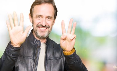Siyah deri ceket gösterme ve parmakları ile işaret giyen orta yaş yakışıklı adam kendinden emin ve mutlu gülümseyerek süre sekiz numara.