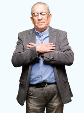 Göğüs kapalı gözlerle ellerinde ve yüzünde minnettar jest ile gülümseyen gözlük takan yakışıklı üst düzey businesss adam. Sağlık kavramı.