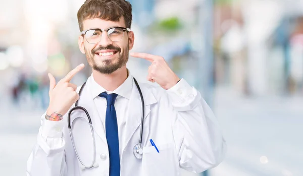 Jovem Médico Vestindo Casaco Hospital Sobre Fundo Isolado Sorrindo Confiante — Fotografia de Stock